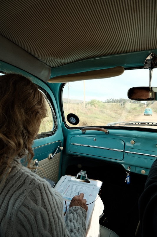 Woman with clipboard in classic VW Beetle